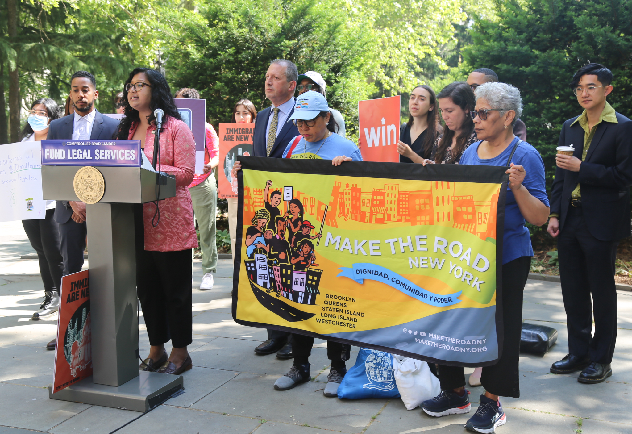 City Councilmember Shahana Hanif stands behind a lectern that reads 