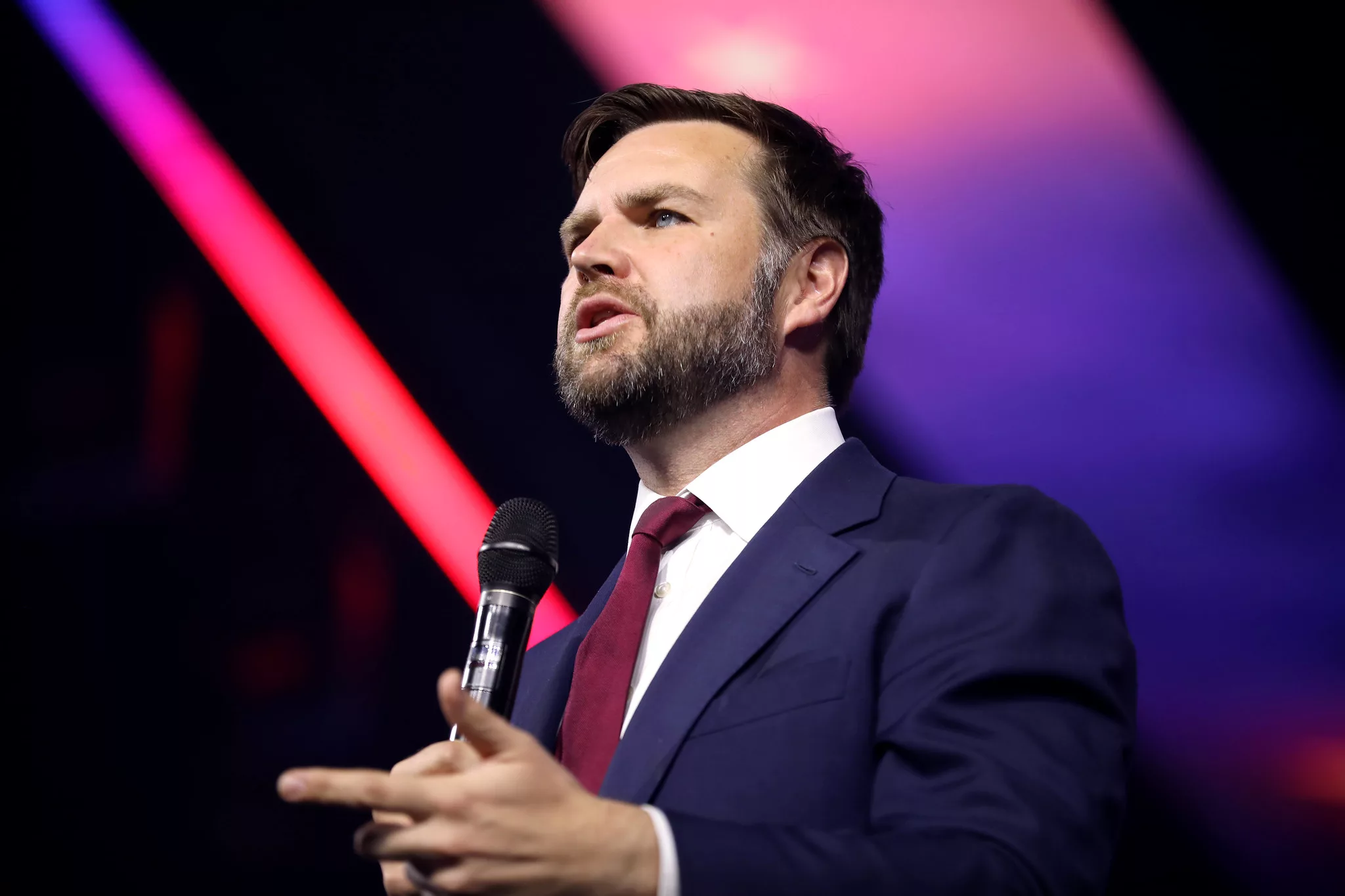 Senator J.D. Vance speaks while holding a microphone.