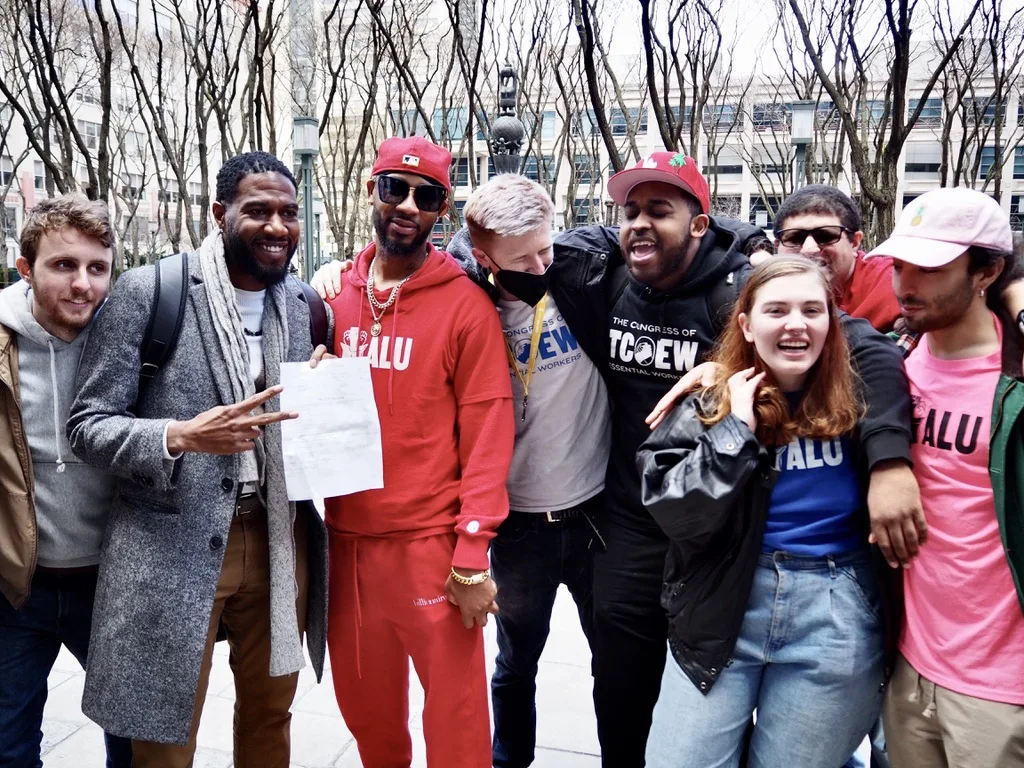 Connor Spence (far left) celebrates with Christian Smalls (third from left), April 1, 2022. Photo: Amir Khafagy for Documented.  