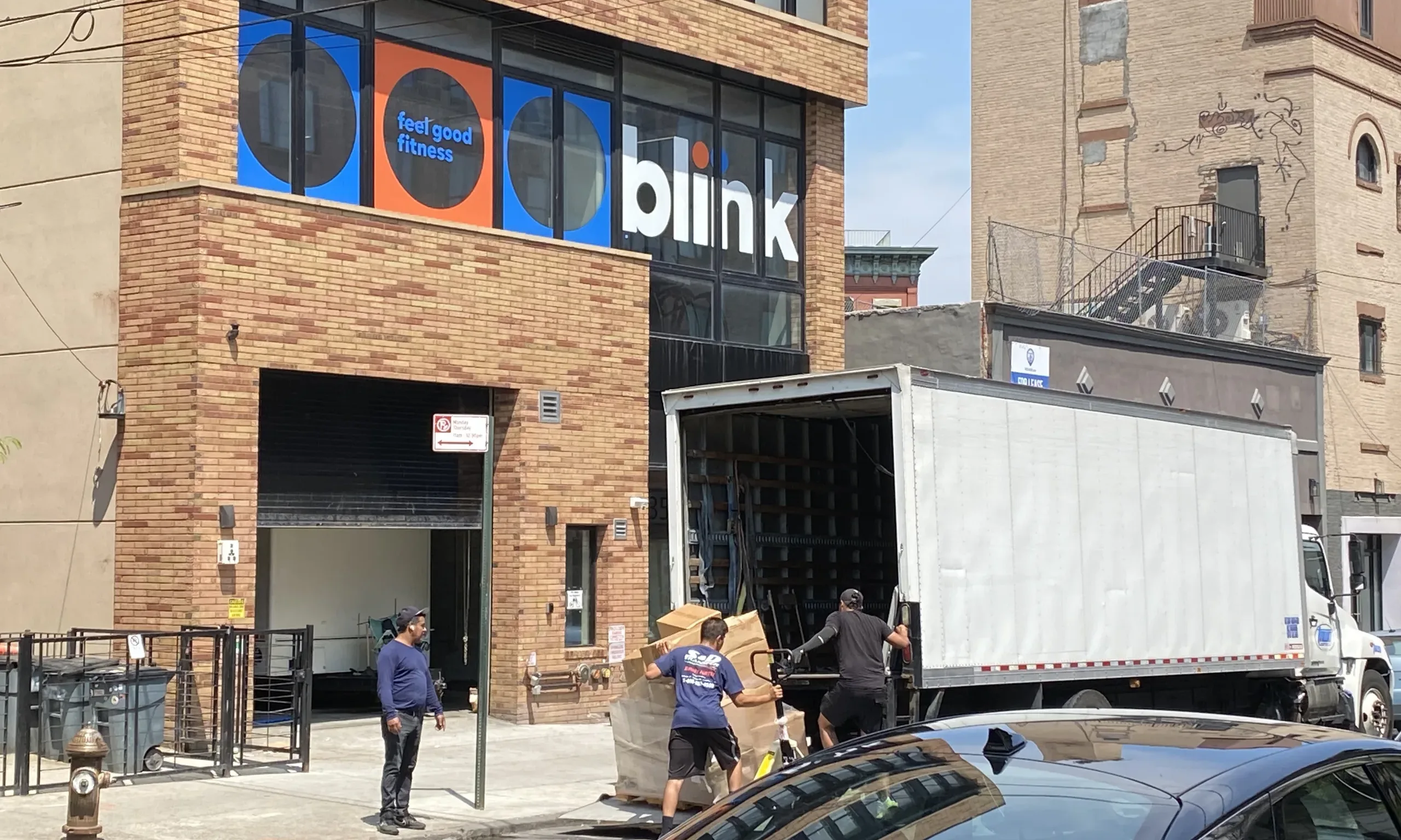 Three men loading storage boxes into an awaiting truck in front of 359 Stockton Street shelter on Monday August 5.